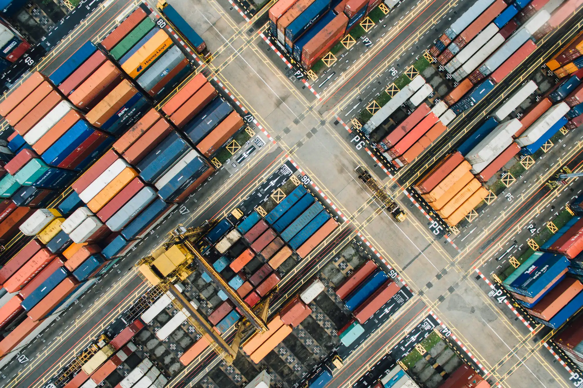 Aerial view of colourful shipping containers arranged in rows at a port